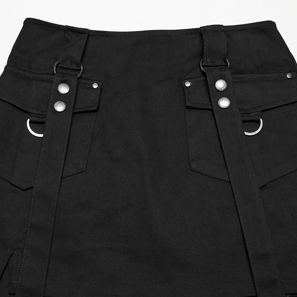 Close-up of a black punk harness dress with utility pockets, zippers, and strap details.