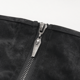 Close-up of a skull zipper on a black fabric, adding an edgy touch to an alternative fashion garment.