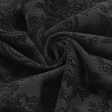 Close-up of black lace fabric featuring intricate floral patterns, perfect for gothic fashion.