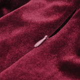 Close-up of burgundy velvet fabric with a zipper detail showcasing luxury and elegance in design.