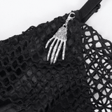 Close-up of a black dress with a silver skeleton hand charm, showcasing gothic lace accents and edgy design.