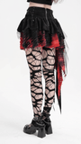 Back view of tiered asymmetrical gothic skirt in black and red, paired with edgy fishnet tights and platform boots.